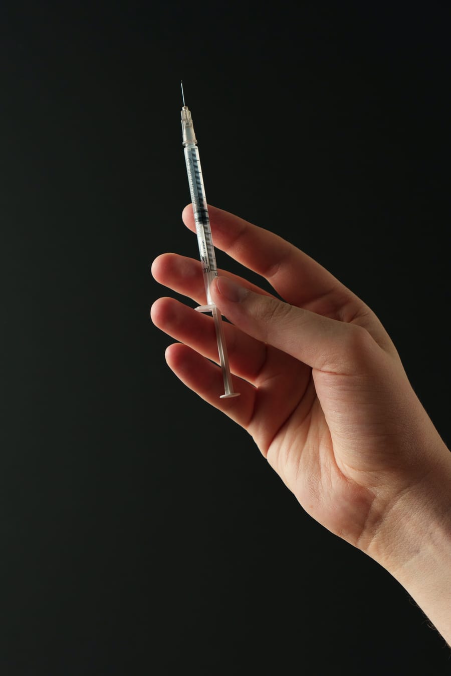 Hand holding a syringe